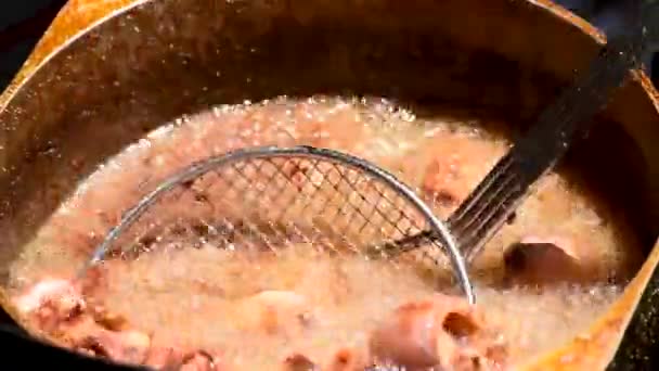 外の日差しの中でイカやイカの揚げ油が泡立つ鍋 — ストック動画