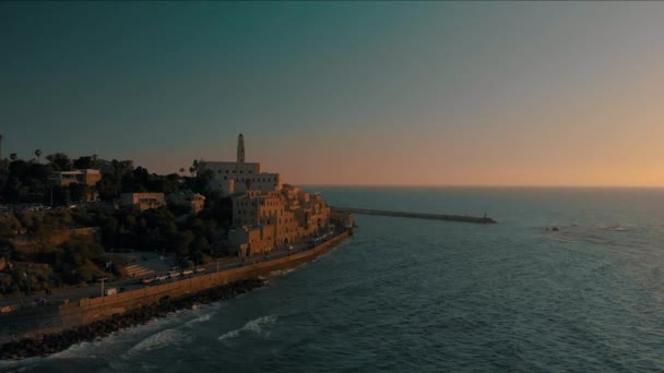 テルアビブ ジャファ日没時間 空中ドローン映像 Jaffaの旧市街と港の上にジャファの聖ピーター教会の周りを飛ぶ — ストック動画