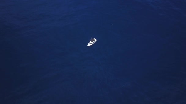 Снимок Беспилотника Показывающий Белую Лодку Сидящую Посреди Глубокого Синего Моря — стоковое видео