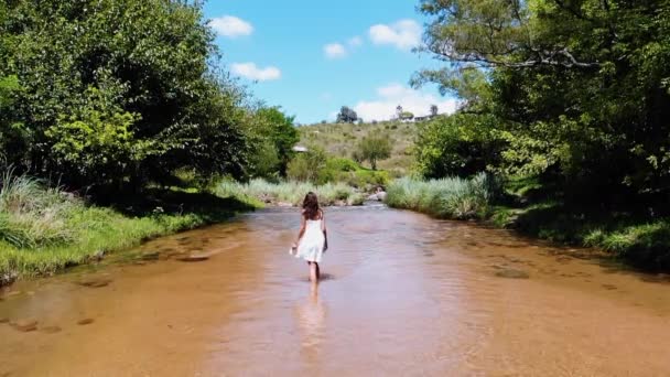 Широкий Замедленный Снимок Женщины Белом Платье Счастливо Проходящей Через Ручей — стоковое видео