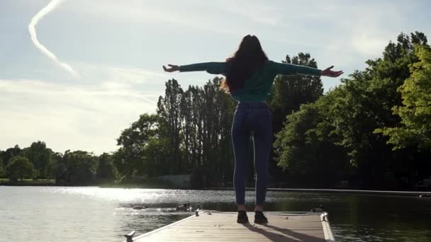 迷人的意大利女人举起双臂 凝视着湖上的日落 女孩举起胳膊庆祝生命和自由 表达感激之情 旅途愉快 — 图库视频影像