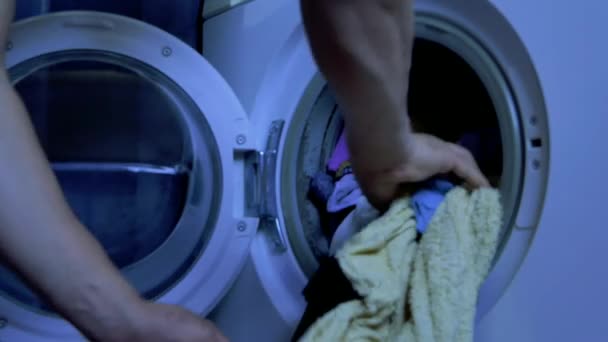 洗濯機から服を取る男の腕 — ストック動画