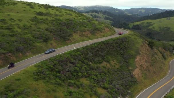 背景に北カリフォルニアの山々の安定したトラフィックと壮大な景色を下に非常に風の強い道路とクレストの空中フライオーバー — ストック動画