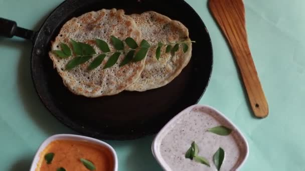 Oothappam Dosaの回転 緑の背景に隔離されたココナッツチュニーイで提供される米レンズ豆と野菜を使用した南インドの朝食 — ストック動画