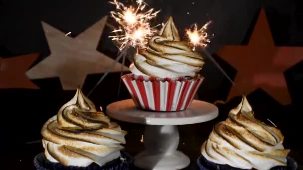 赤い白と青のカップケーキの周りで爆発するキラキラトーストしたメレンゲの渦の上 — ストック動画
