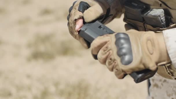 スローモーション 砂漠に位置する米海兵隊は 彼のアサルトライフルのクリップに弾丸を入れてから 銃にロードします — ストック動画