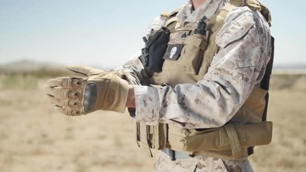 慢动作 驻扎在沙漠中的一名美国海军陆战队员将一只战术手套放在他的左手上 — 图库视频影像