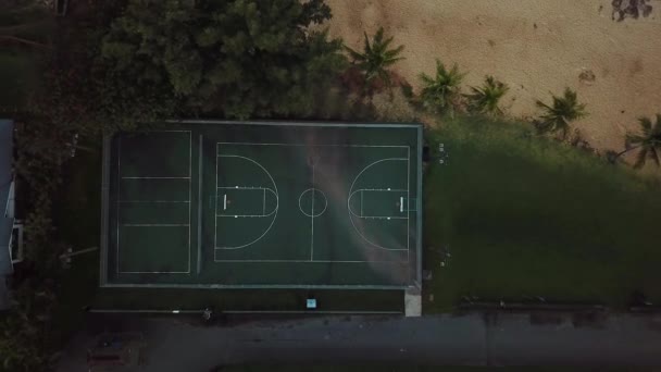 無人機空の緑色のバスケットボールコートの上で直接撃たれた この裁判所は ハワイ州オアフ島のシャーク コーブのビーチにあります — ストック動画