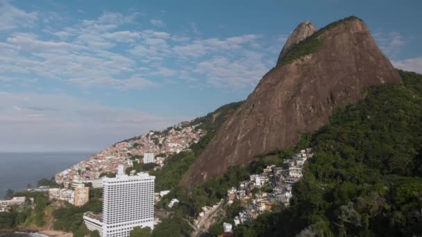 从空中径直升空 揭示了里约热内卢的两兄弟山脉山峰 其陡峭的斜坡上有维迪加尔贫民窟 自然天际线景观与密集的城市棚户区 — 图库视频影像
