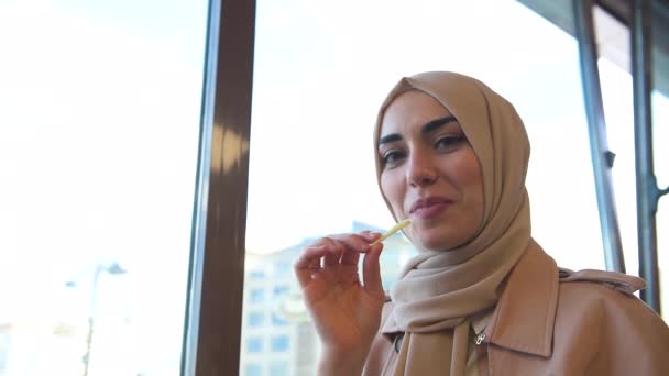 美丽的穆斯林妇女头巾和时尚现代时尚的衣服吃土豆薯条在餐厅与快乐的笑容 现代穆斯林女性生活方式或商业理念 — 图库视频影像