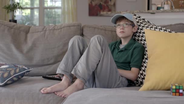 Ein Süßer Junge Schaut Tagsüber Auf Der Couch Fern — Stockvideo