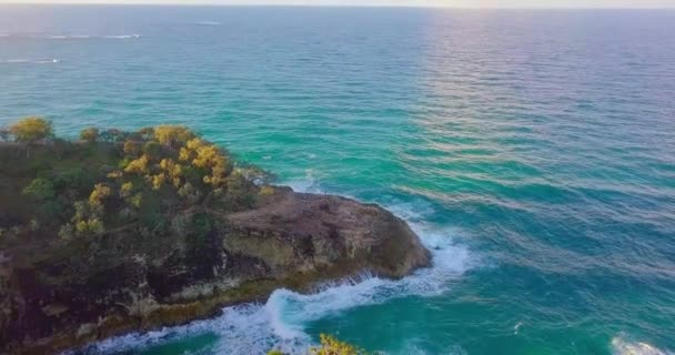 崖や植生の空中ショットを傾ける 日没時に波と泡が飛び散るターコイズブルーの水 オーストラリアのストラドブルーク島 — ストック動画