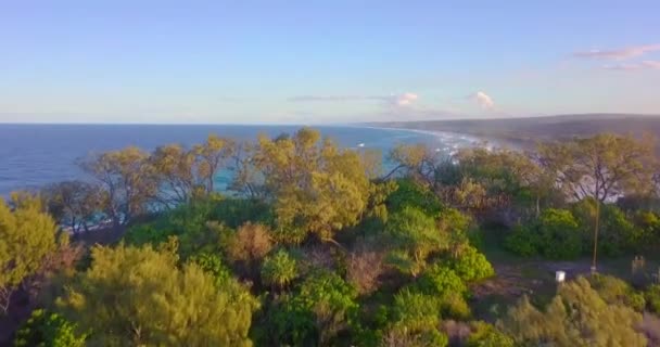 日没時に波と野生のビーチやターコイズブルーの海の速い空中ショットを明らかにする — ストック動画