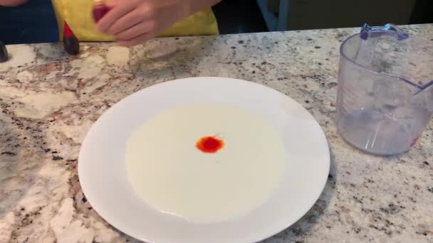 Küçük Eller Beyaz Süt Tabağına Farklı Renkte Gıda Boyası Döküyor — Stok video