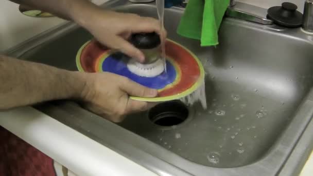 Άνθρωπος Πλένει Ένα Έντονα Χρωματιστό Και Σχεδιασμένο Πιάτο Τροφίμων Στο — Αρχείο Βίντεο
