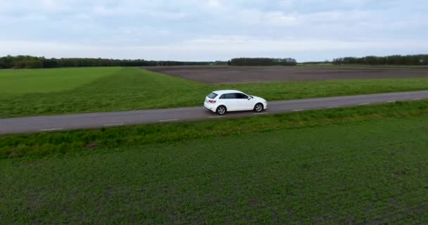 Aerial Drone Shot White Car Conduciendo Narrow Country Side Road — Vídeos de Stock