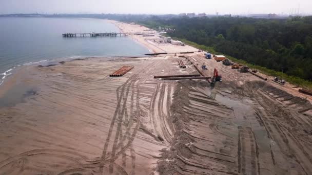 海滩漂泊空中射击 海滩填海无人机画面海滩上的建筑设备和管道 推土机和挖掘机 2019年春 波兰格但斯克 — 图库视频影像