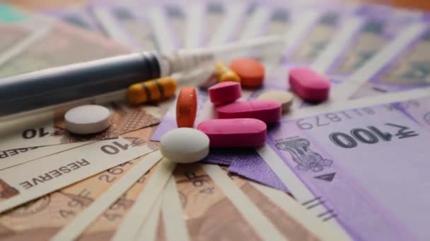 印度货币上的医疗费用概念 药丸和注射器 — 图库视频影像