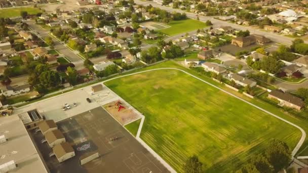 Drone Shot Green Elementary School Field Kids Riding Bikes Blacktop — Stock video