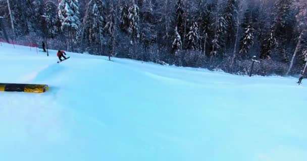Sidovy Över Snowboardåkare Som Hoppar Från Sluttning Terrängpark — Stockvideo