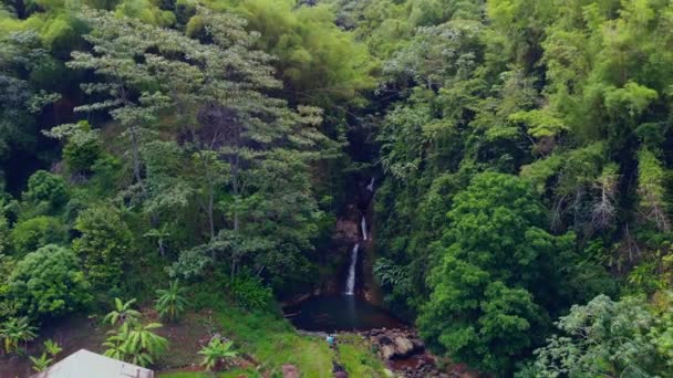 一对夫妇坐在美丽的格林纳达热带雨林中的一个史诗般的瀑布的底部 — 图库视频影像