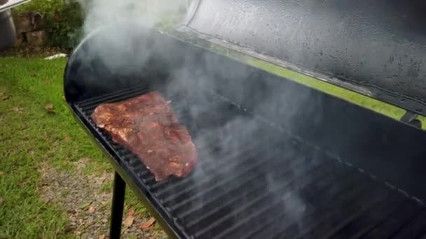 男は喫煙者バーベキューグリルで味付け生牛肉の作品を配置します — ストック動画