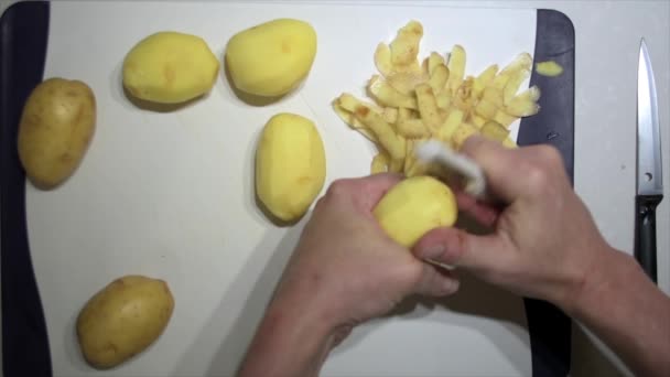 Ovanifrån Närbild Ett Par Händer Skalning Potatis Hackbräda — Stockvideo