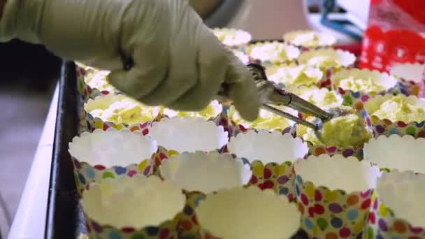 컵케이크 냄비에 맛있는 반죽을 사용하고 아이스크림 숟가락을 넣는다 집에서 만드는 — 비디오