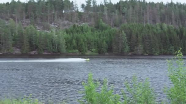 看到一名男子在挪威湖上驾驶喷气式滑翔机超速行驶 — 图库视频影像