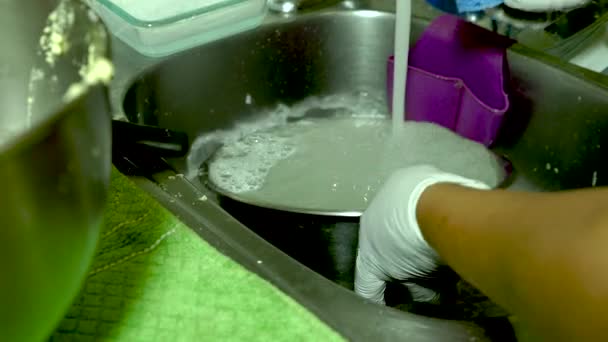 Человек Перчатках Моет Посуду Раковине Кухни Проточной Водой Подозревая Глобальном — стоковое видео