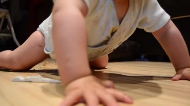 チョコレートビスケットを食べて床に這う可愛い赤ちゃん ドリーを撃ち抜き — ストック動画
