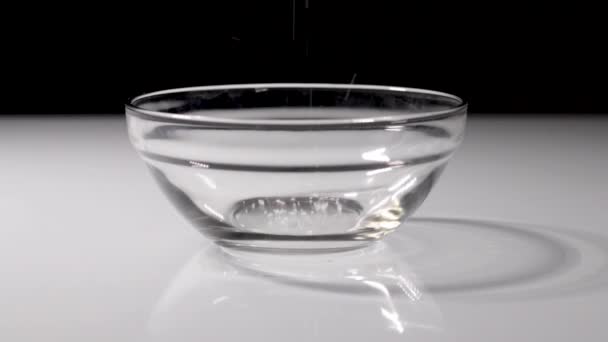 一些糖倒入一个深色背景的小玻璃杯的慢镜头 — 图库视频影像