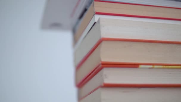利害関係にある本のクローズアップ 上から下への滑らかな動き カラフルな本の表紙と明るい背景の本の詳細 — ストック動画