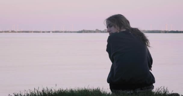 美丽的年轻女子在日落时在湖边等她的男朋友 — 图库视频影像