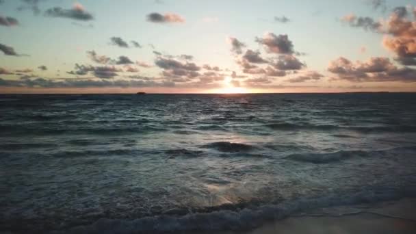 无人机平稳地在夏威夷海滩上空向后飞 地平线上升起美丽多彩的日出 — 图库视频影像