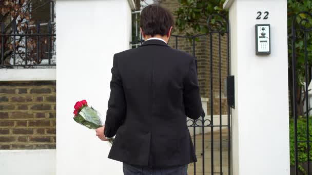 Hombre Esperando Frente Una Puerta Con Montón Rosas Sus Manos — Vídeos de Stock