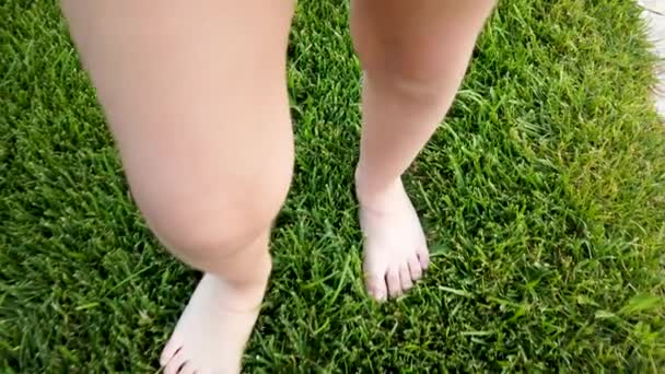 公園や庭の草の上を歩いている間 小さな女の子の足 — ストック動画