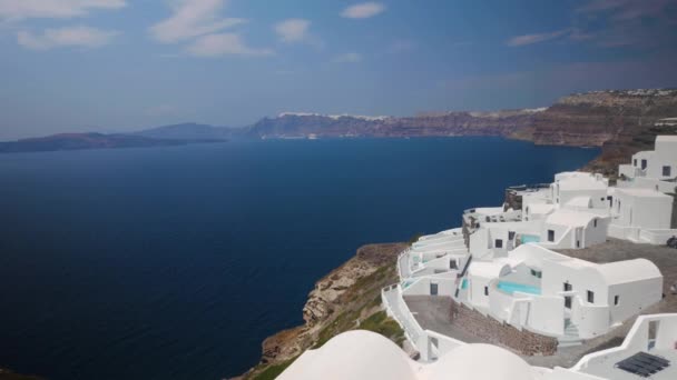 白い建物とサントリーニ島の景色を望むクリフホテルのハンドヘルドワイドショット Thira — ストック動画