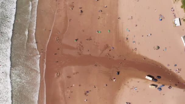 人々と北デヴォンの黄金の砂浜の空中フライオーバー日光浴 — ストック動画