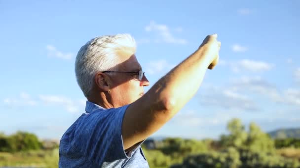男のゴルファーが手で太陽を遮って遠くを見ると — ストック動画