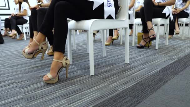 グループの女性の練習ファッションは 多くの女性がミス美容ページェントコンテストのためのステップスタンド座ってハイヒールの靴を教えるためにプロのコーチとモデルのように椅子の上に座る — ストック動画