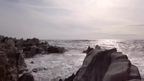 サンセットのロッキービーチで波が打ち寄せる — ストック動画