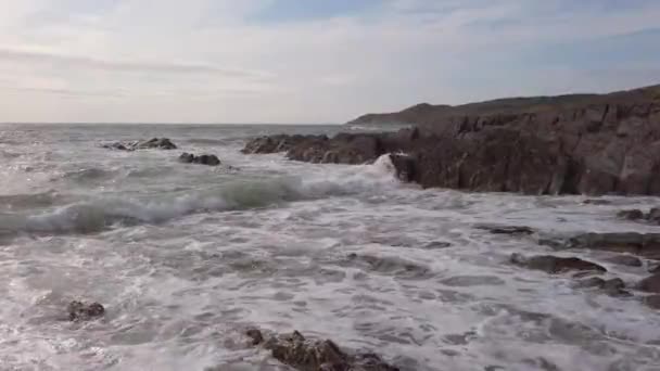 日没の間にデヴォンの岩の入り江で波が砕ける — ストック動画