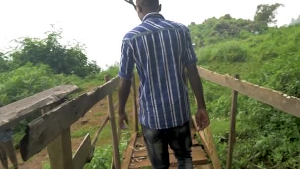 Tiro Rastreamento Câmera Lenta Jovem Africano Atravessando Uma Ponte Madeira — Vídeo de Stock
