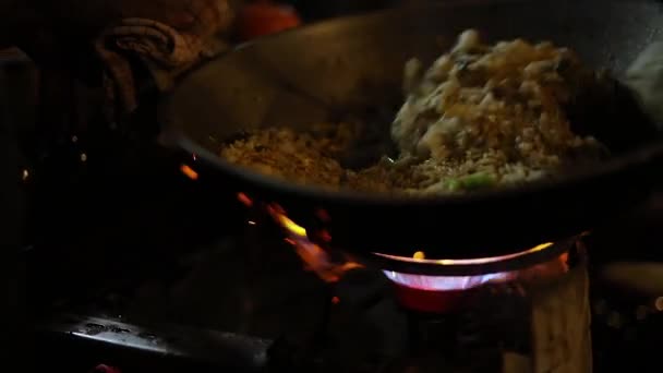 インドネシア料理を作るストリートベンダーの素晴らしいスローモーションショット 食べ物はストーブの上の鍋で調理しています ナシゴレン 玉ねぎ 各種スパイスをかけたもの — ストック動画