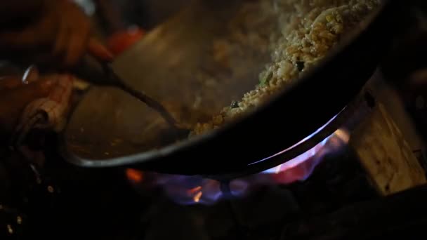 炎の上の鍋で販売するために彼らのインドネシア料理を調理する通りのベンダーのショット ナシゴレン 玉ねぎ 各種スパイスをかけたもの — ストック動画