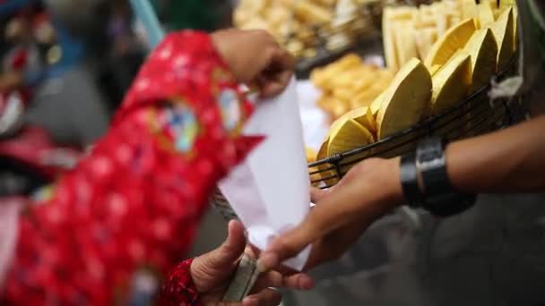 ジャカルタの通りの市場で空腹の顧客に彼らの深い揚げインドネシア料理を販売している露店のショット — ストック動画