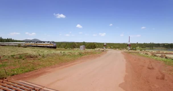 Aerial Passenger Train Passes Intersection Dirt Road Protected Active Railroad — Stock Video