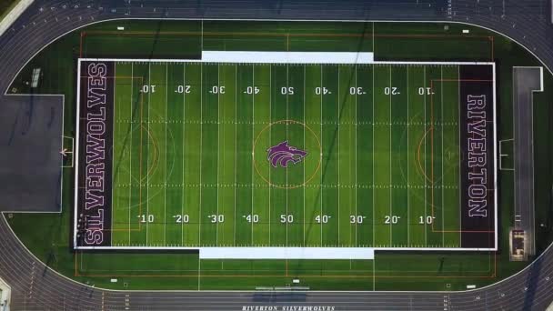 无人机在一个空荡荡的高中足球场上空鸣枪 周围都是跑道 在战场的两边也可以看到偷猎者 田园来自犹他州里弗顿的里弗顿高中 — 图库视频影像