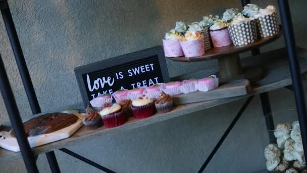 婚礼接待处的甜点桌慢动作镜头 架子上有软糖 纸杯蛋糕 饼干等 — 图库视频影像